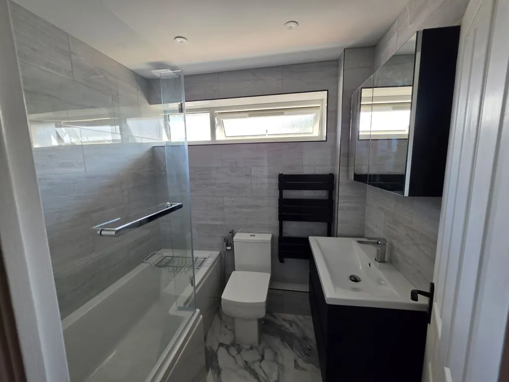After: Grey-tiled family bathroom